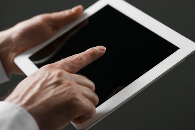 Photo of Closeup view of man using new tablet on black background