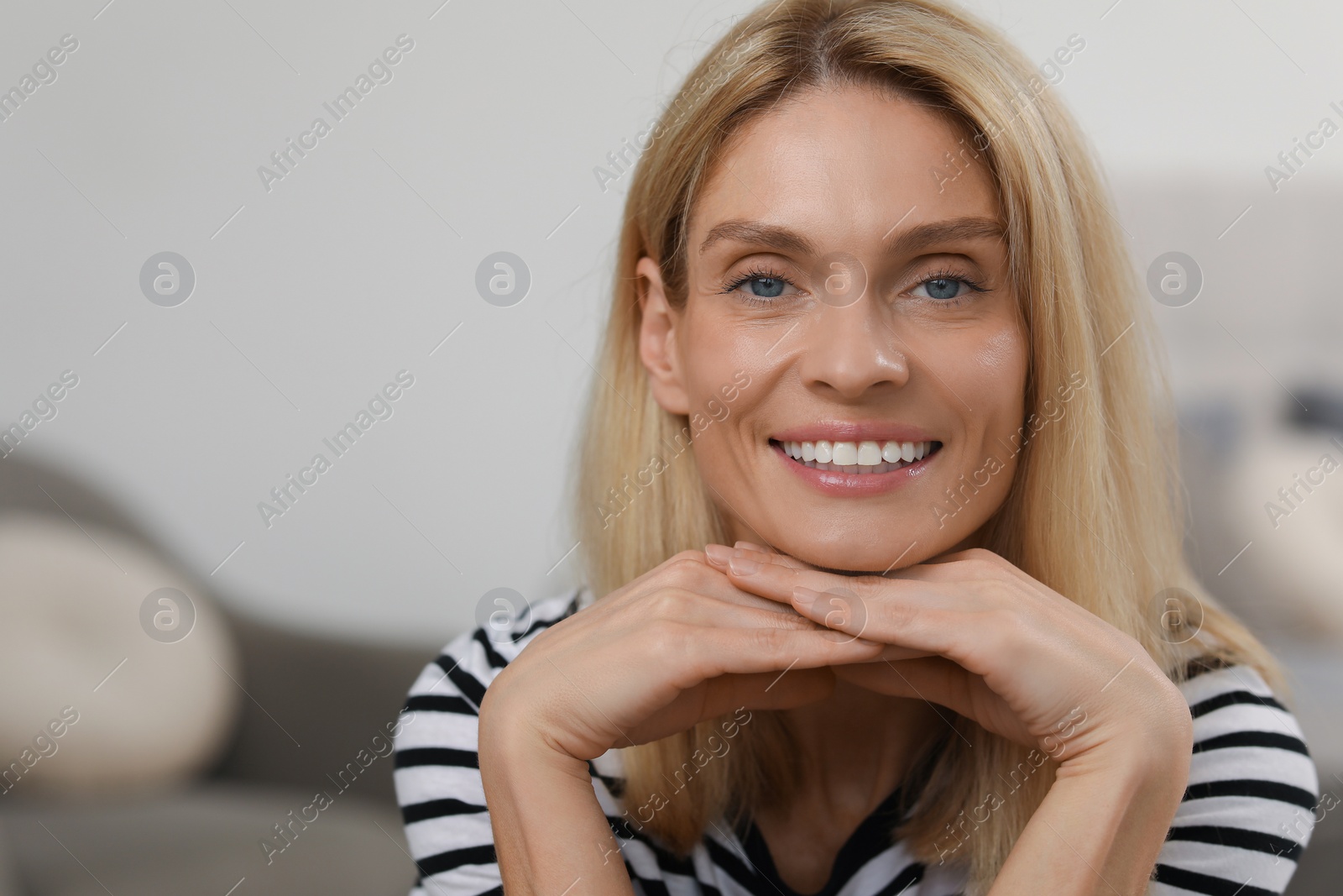 Photo of Portrait of beautiful woman with blonde hair. Attractive lady smiling and looking into camera. Space for text