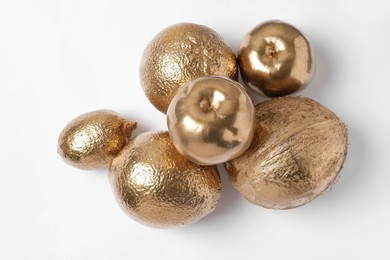 Photo of Shiny stylish golden fruits on white background. Decor elements