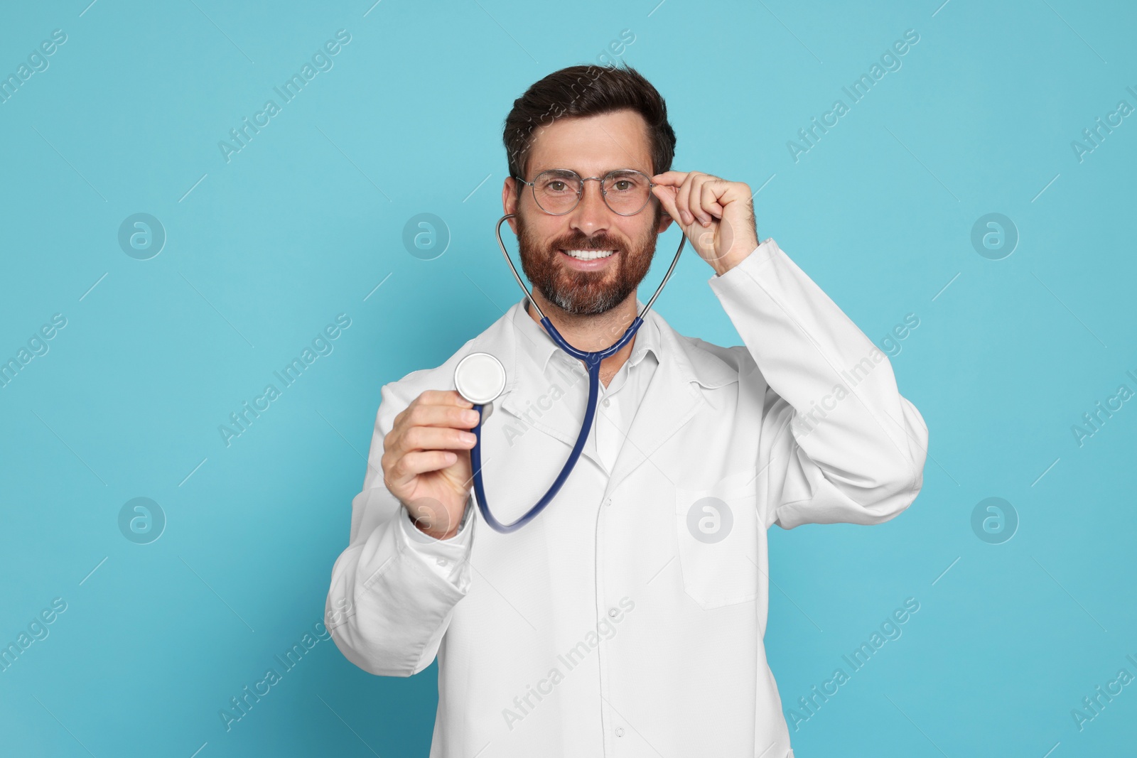 Photo of Doctor with stethoscope on light blue background