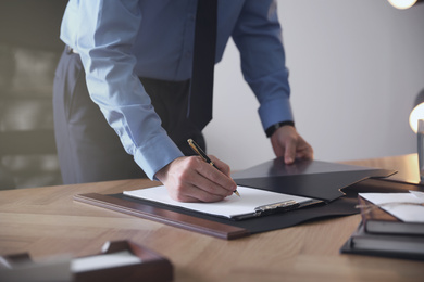 Male lawyer working at table in office, closeup