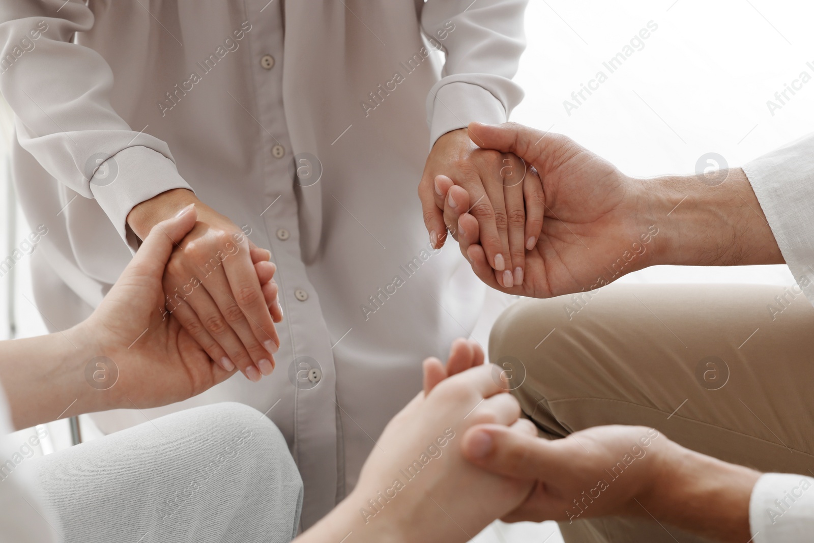 Photo of Group of religious people holding hands and praying together indoors, closeup