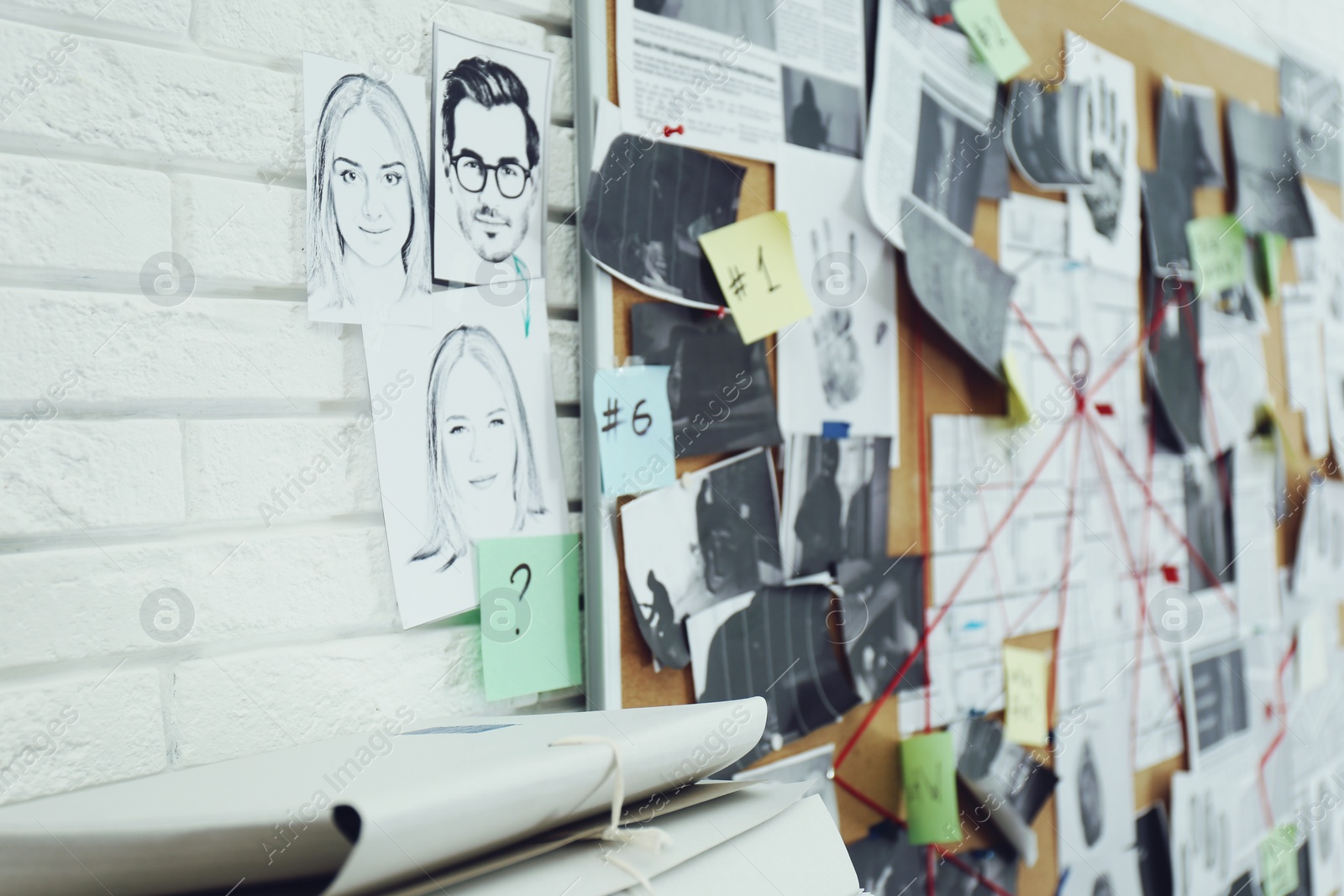 Photo of Investigation board on white brick wall in detective office