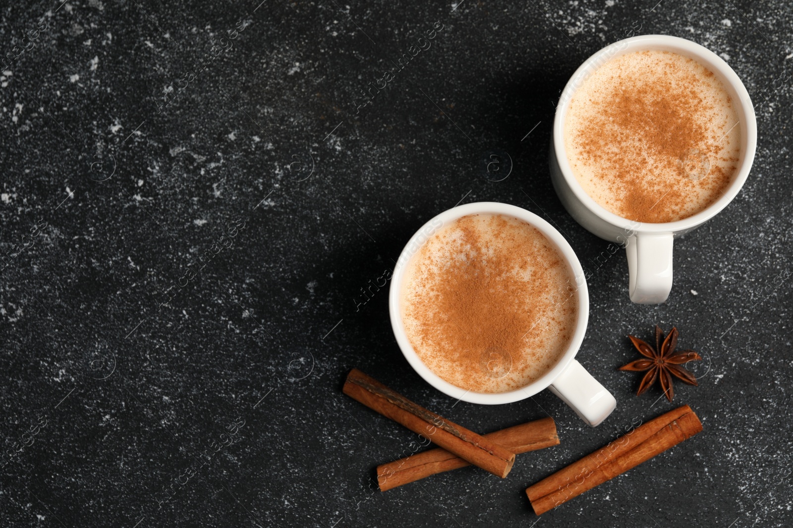 Photo of Delicious eggnog with anise and cinnamon on grey table, flat lay. Space for text