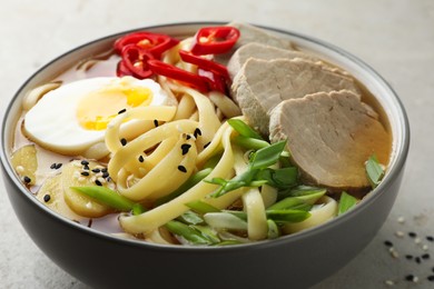 Photo of Delicious ramen in bowl on light table, closeup. Noodle soup