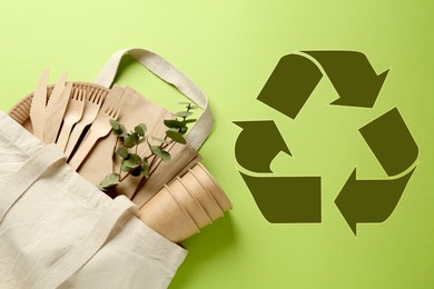 Image of Flat lay composition with eco friendly products and recycling symbol on light green background