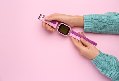 Photo of Girl with stylish smart watch on pink background, top view. Space for text