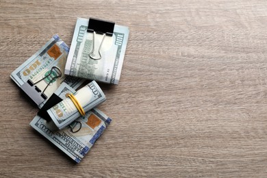Many dollar banknotes on wooden table, flat lay. Space for text