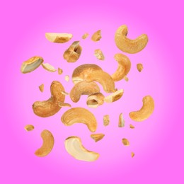 Image of Tasty cashew nuts flying on pink background