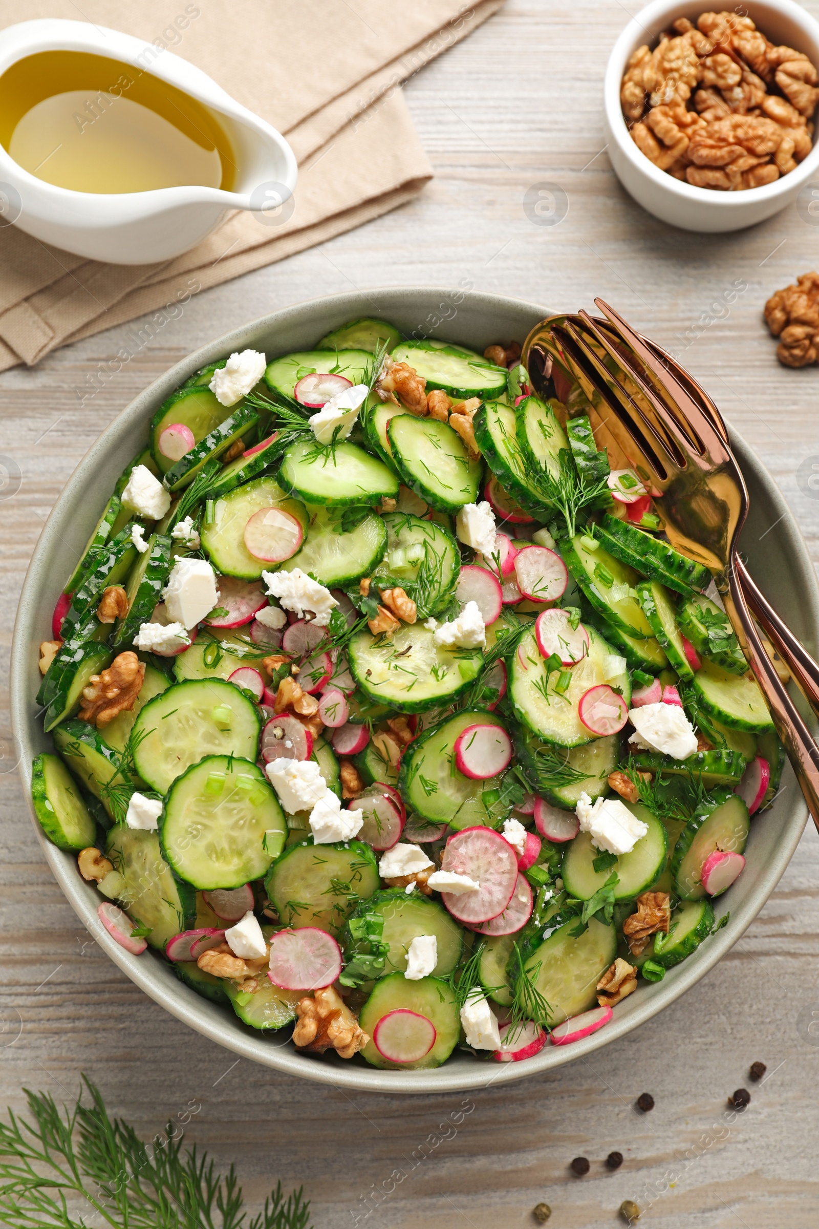 Photo of Delicious cucumber salad served on white wooden table, flat lay