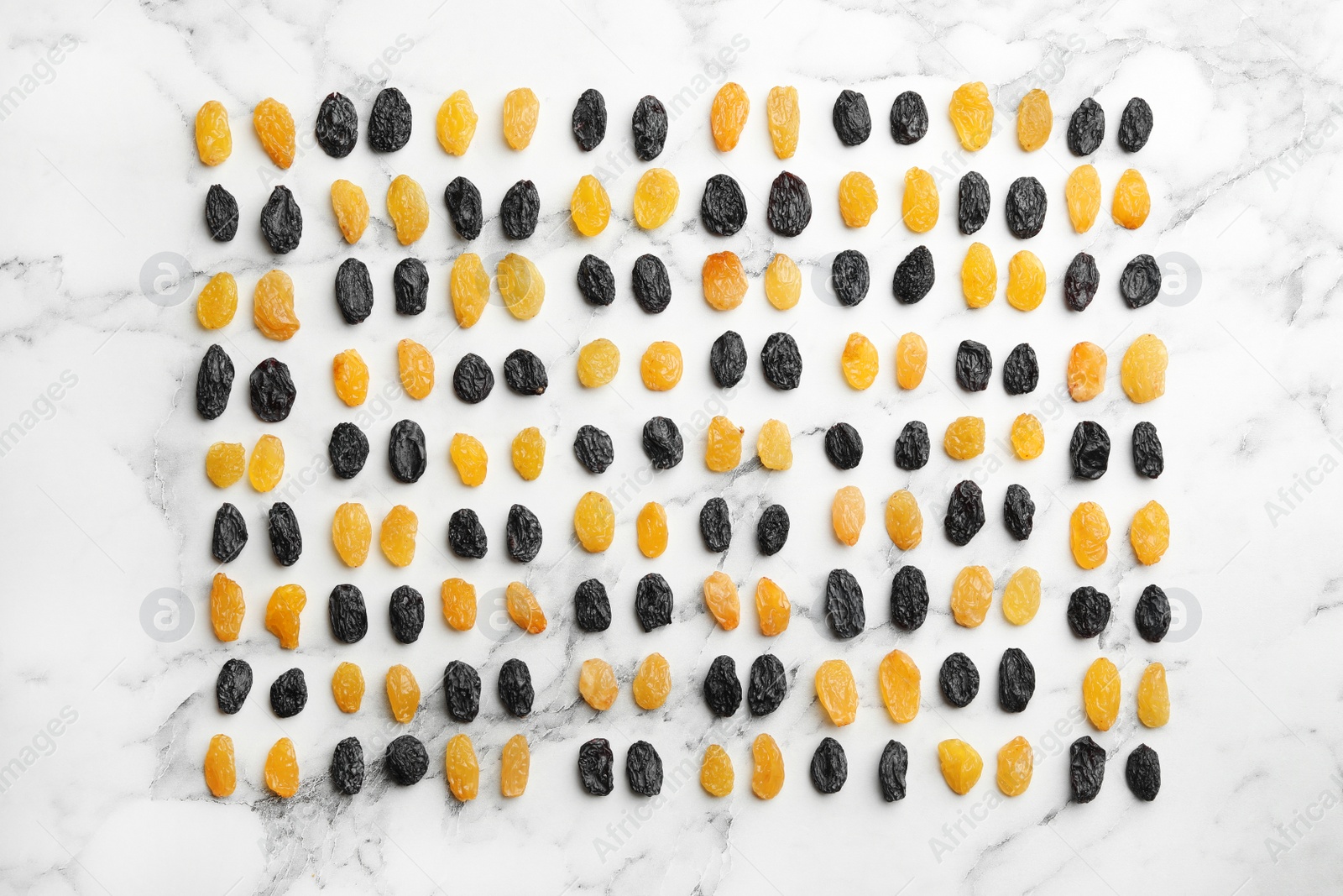 Photo of Flat lay composition with raisins on marble background. Dried fruit as healthy snack