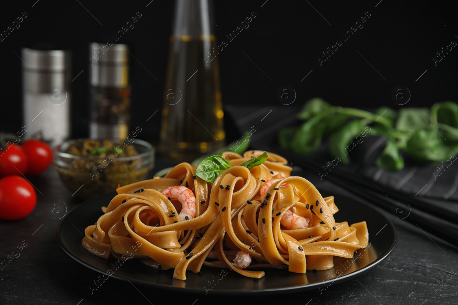 Photo of Tasty buckwheat noodles with shrimps served on black table
