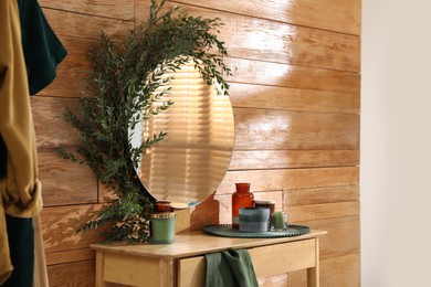 Stylish dressing table and mirror decorated with green eucalyptus in room