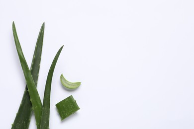 Cut aloe vera leaves on white background, flat lay. Space for text