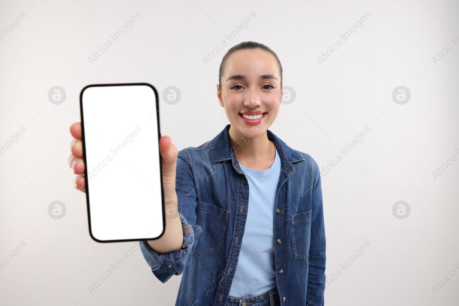 Photo of Young woman showing smartphone in hand on white background