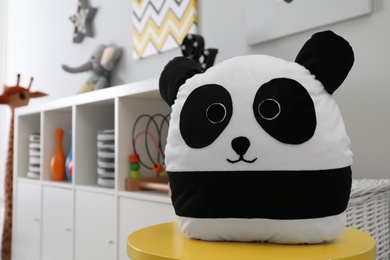 Photo of Stuffed panda toy on table in child's room. Space for text