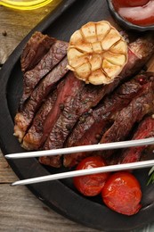 Photo of Delicious grilled beef with tomatoes and spices on wooden table, top view