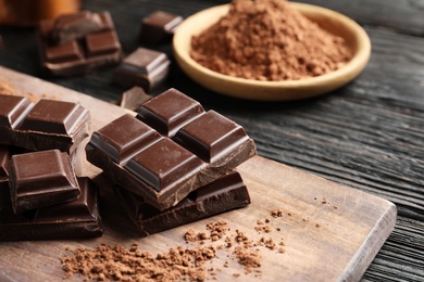 Pieces of black chocolate on wooden board