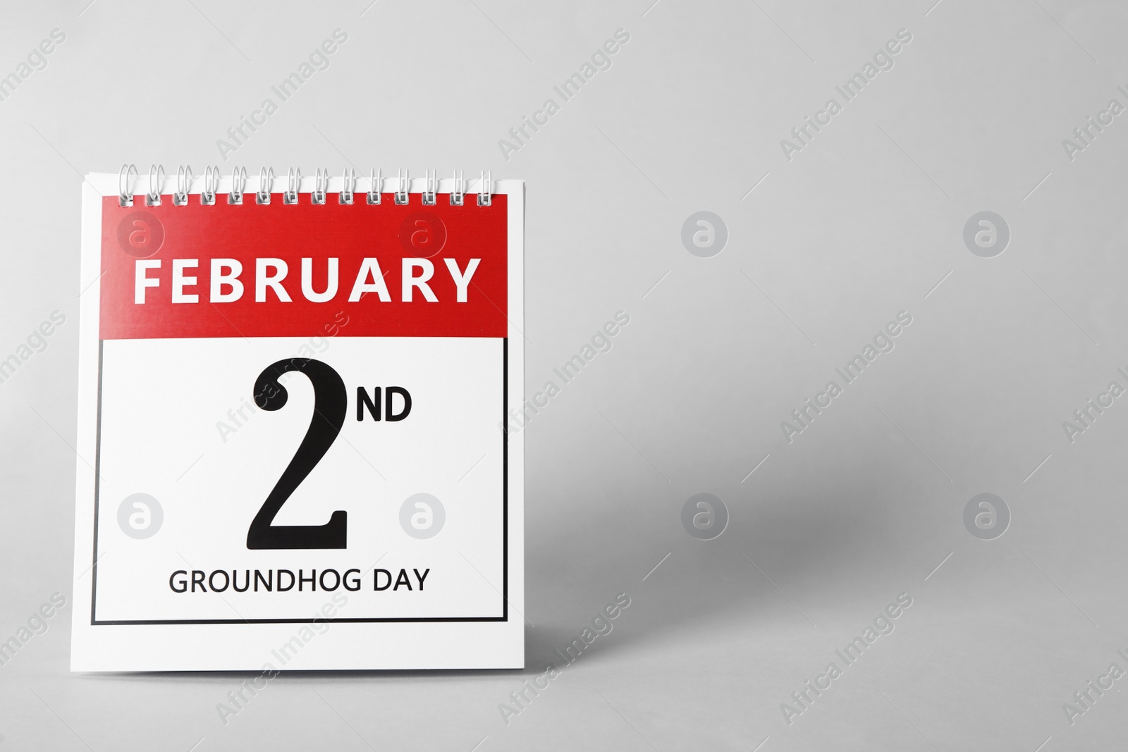 Photo of Calendar with date February 2nd on light background, space for text. Groundhog day