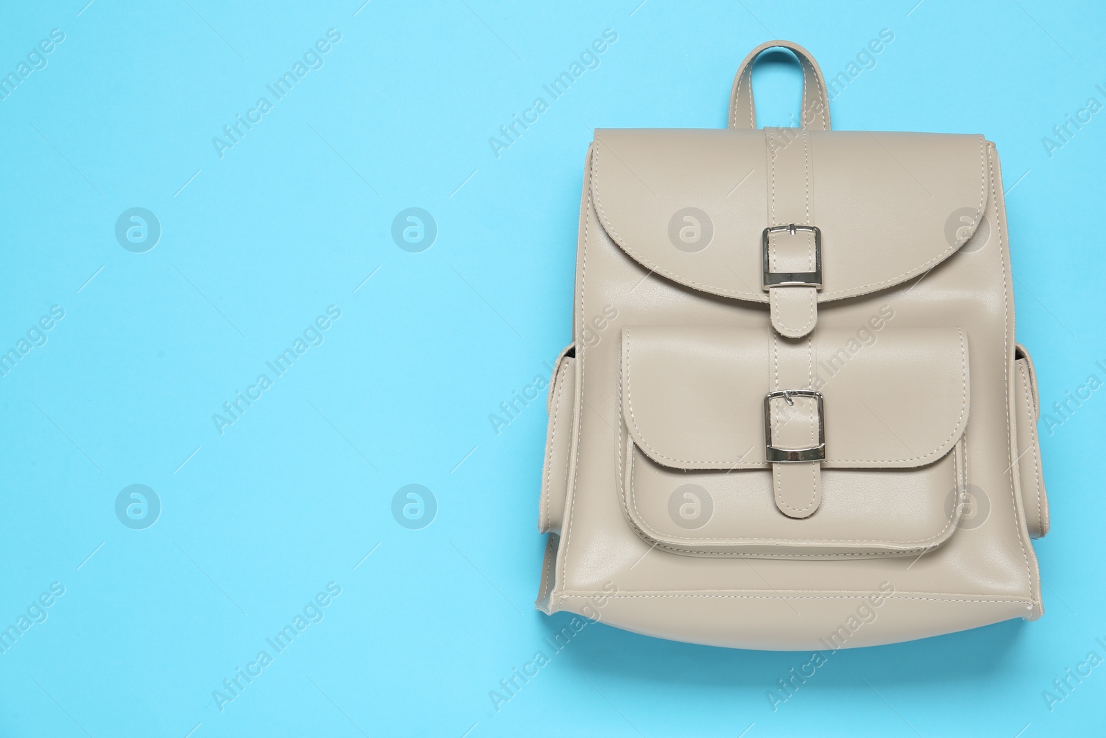 Photo of Stylish urban backpack on light blue background, top view. Space for text