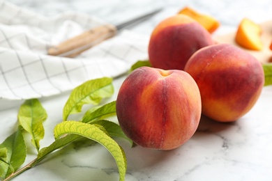 Photo of Fresh sweet peaches on white marble table, closeup