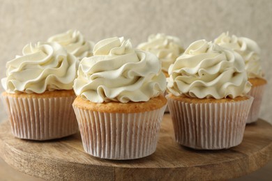 Photo of Tasty vanilla cupcakes with cream on table, closeup