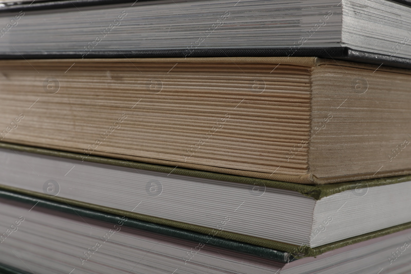 Photo of Stack of many different hardcover books as background, closeup