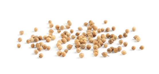 Scattered dried coriander seeds on white background