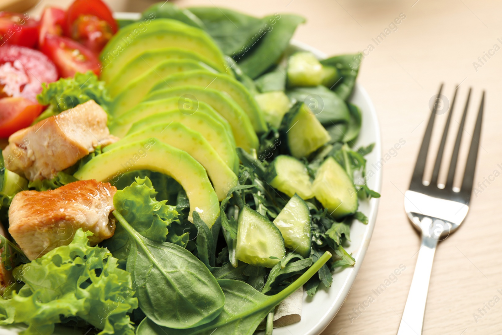 Photo of Delicious avocado salad with fried chicken on table, closeup