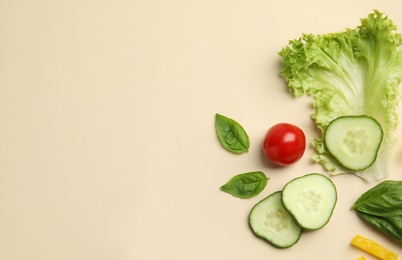 Photo of Flat lay composition with fresh salad ingredients on beige background, space for text
