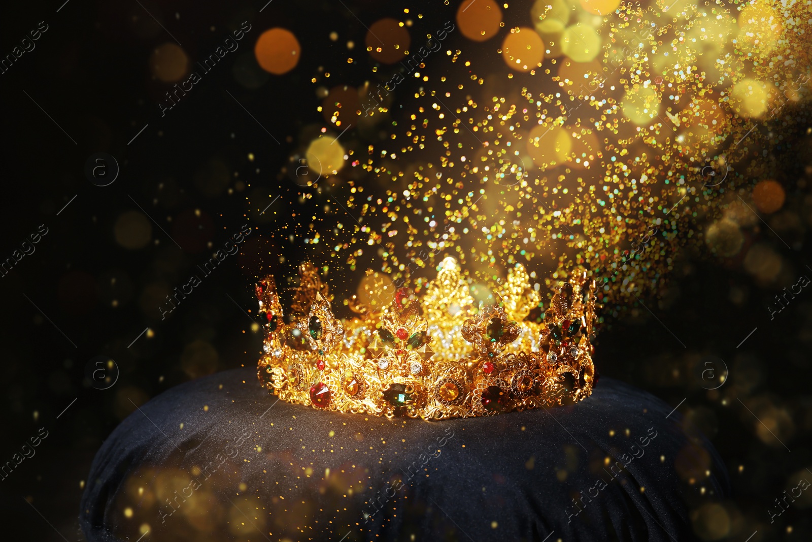 Image of Fantasy world. Beautiful golden crown lit by magic light on pillow
