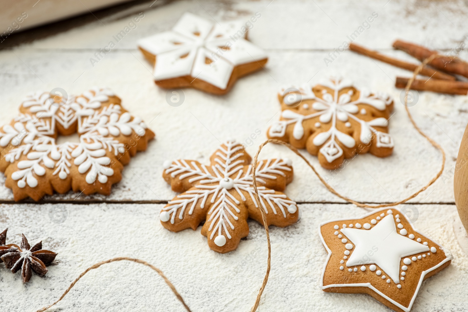 Photo of Delicious homemade Christmas cookies and flour on wooden table, closeup