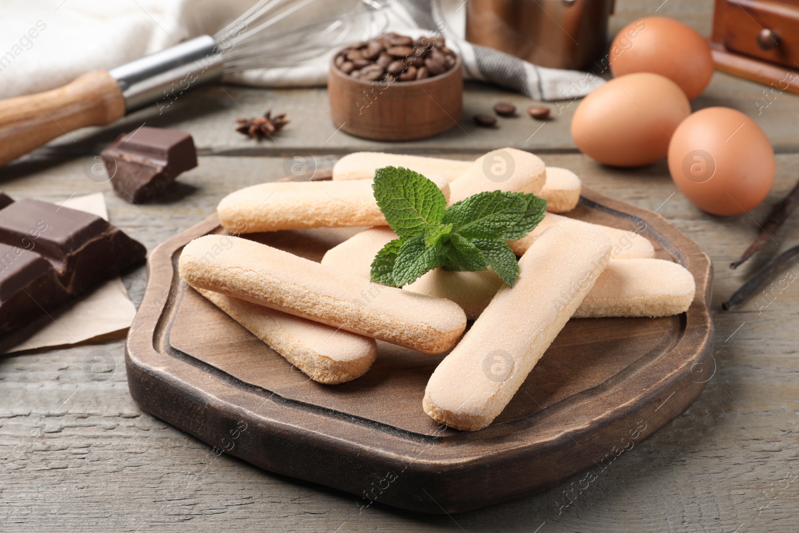 Photo of Tasty cookies with mint and other ingredients for tiramisu on wooden table