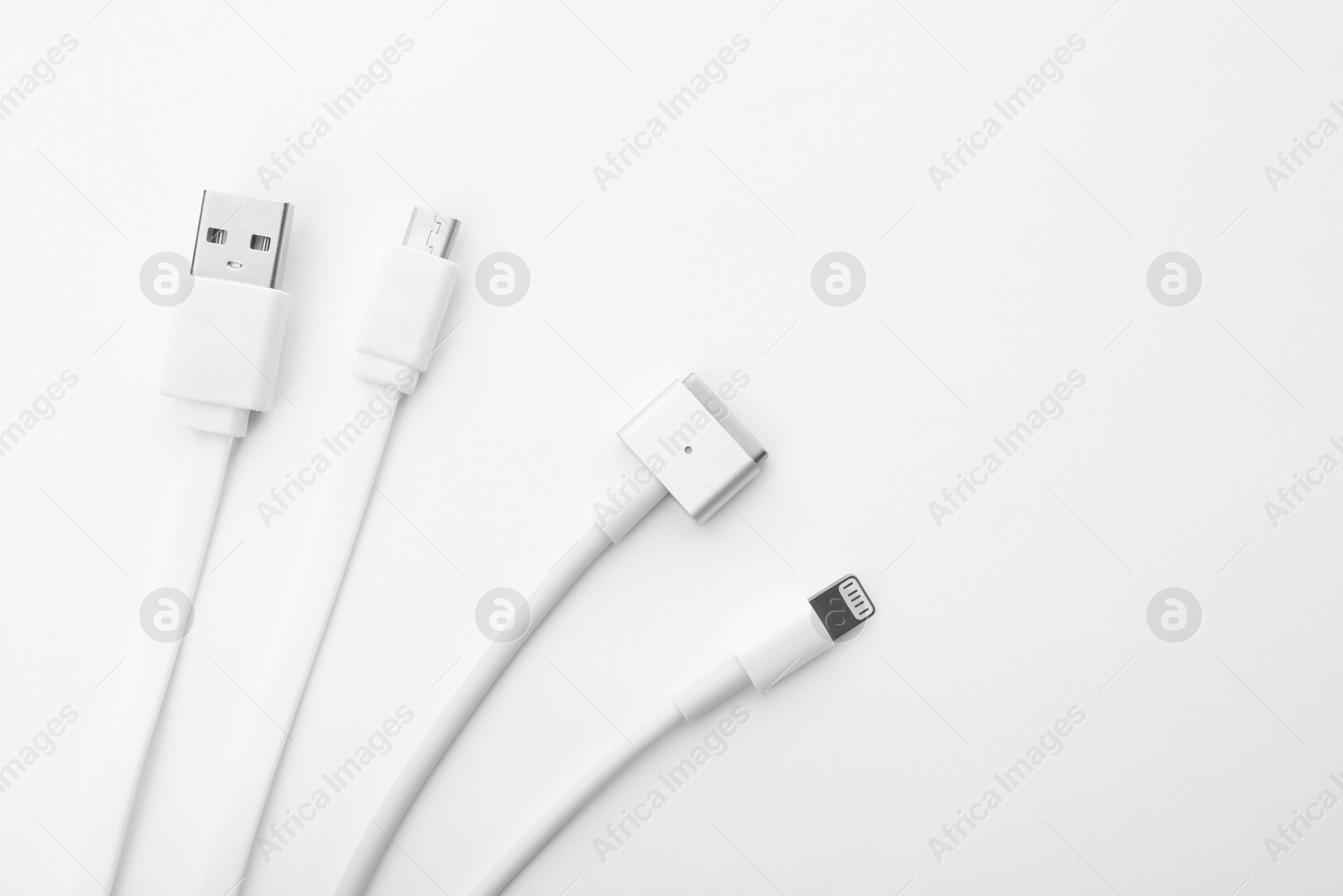 Photo of Charge cables on white background, top view. Modern technology