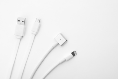 Photo of Charge cables on white background, top view. Modern technology