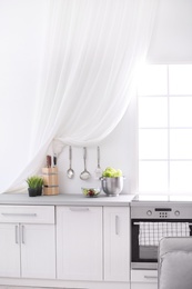 Photo of Light kitchen interior with modern oven and window