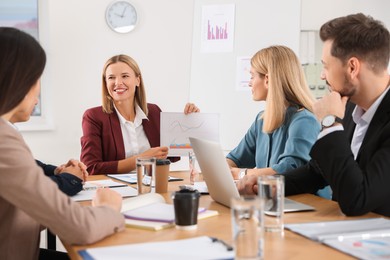 Photo of Businesswoman showing chart on meeting in office