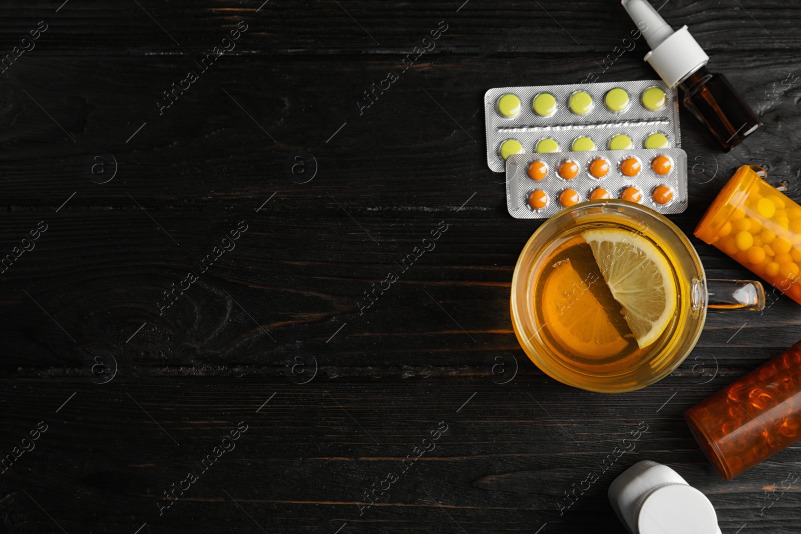 Photo of Flat lay composition with cold remedies on black wooden table, space for text. Sore throat treatment