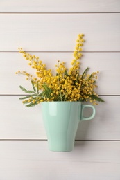 Photo of Bouquet of beautiful mimosa flowers on white wooden table