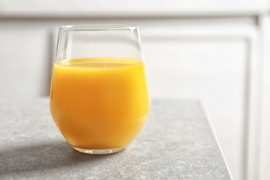 Glass of orange juice on table