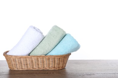 Photo of Fresh towels on wooden table against white background