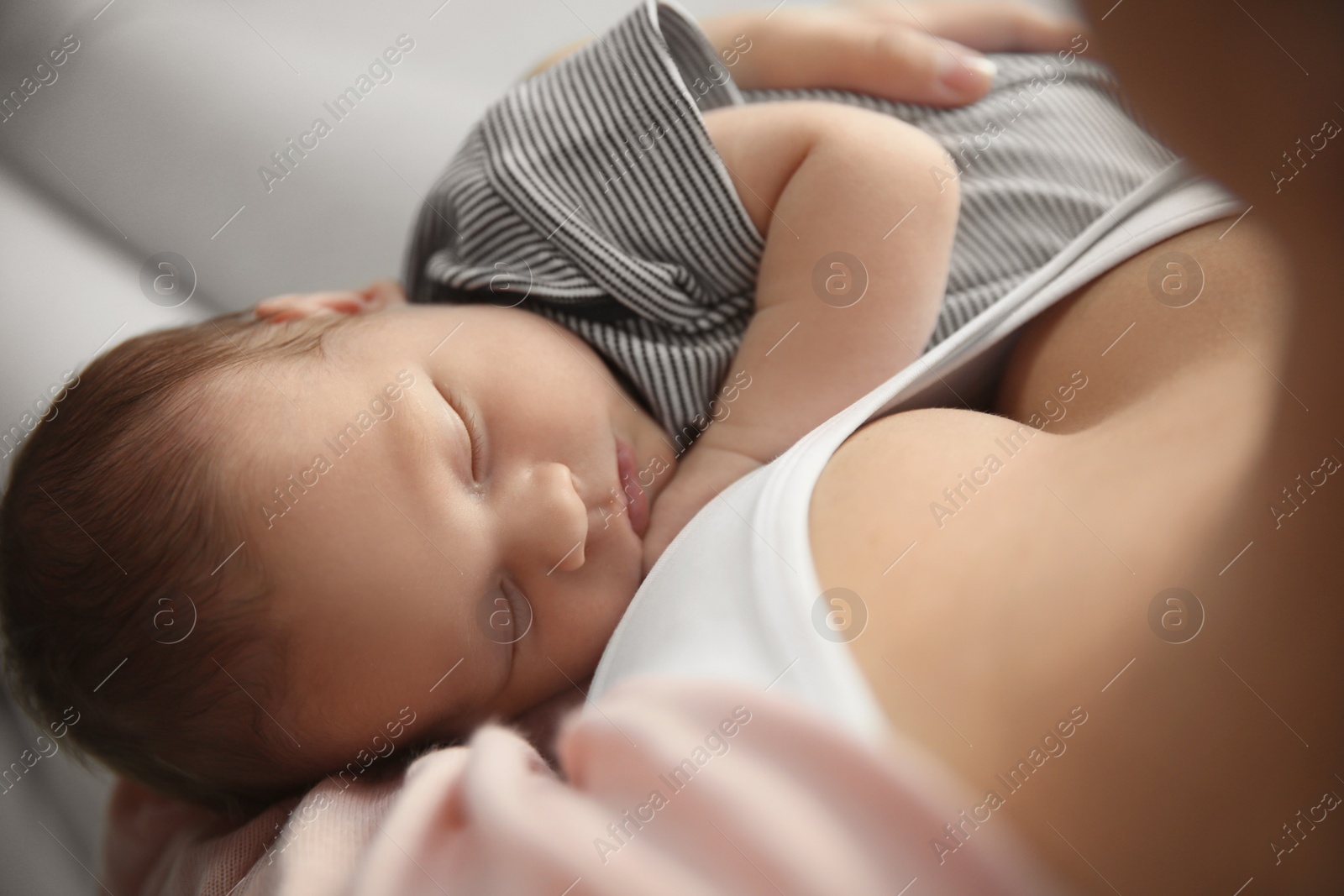 Photo of Young woman holding her newborn baby, closeup