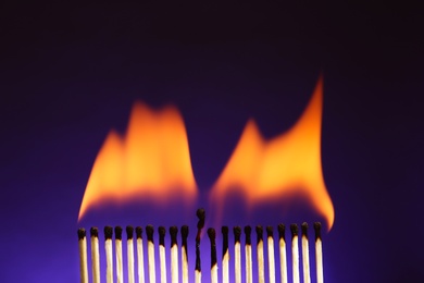 Line of burning matches on color background