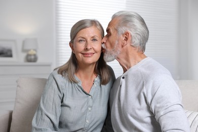 Senior man kissing his beloved woman at home