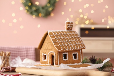 Photo of Beautiful gingerbread house decorated with icing on wooden board