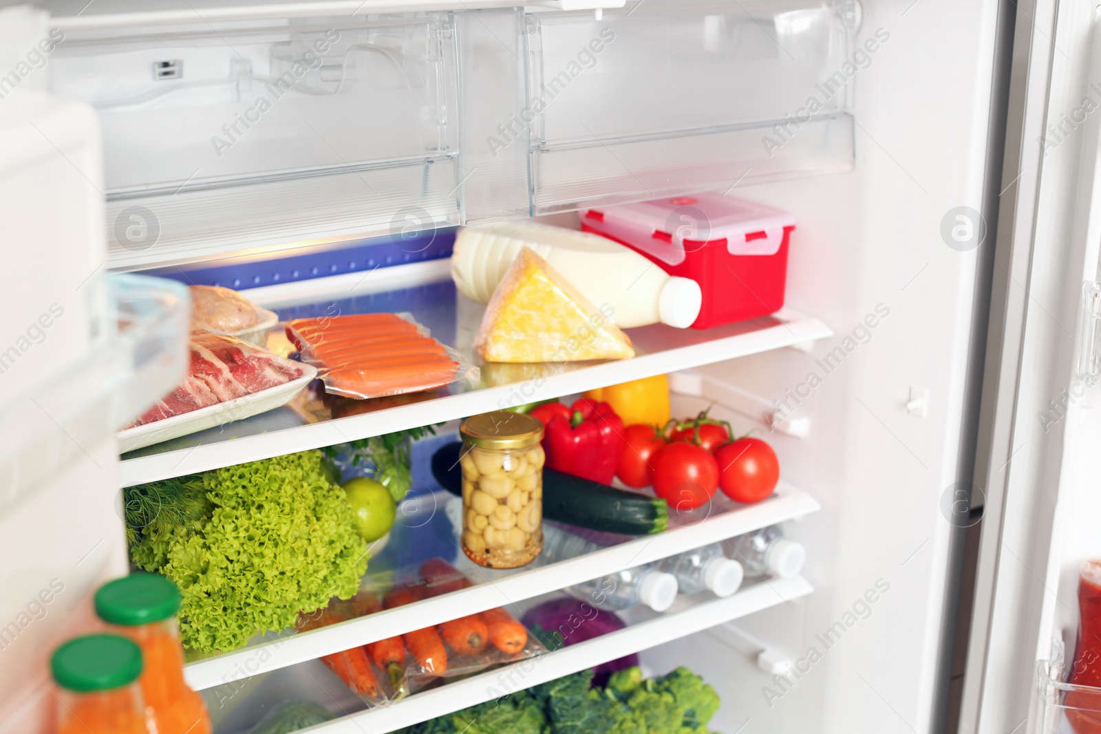 Photo of Open refrigerator with fresh food on shelves