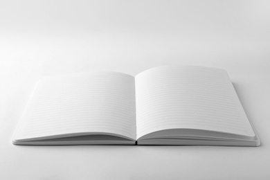 Photo of Stylish open notebook with blank sheets isolated on white