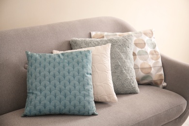 Photo of Different soft pillows on sofa in room