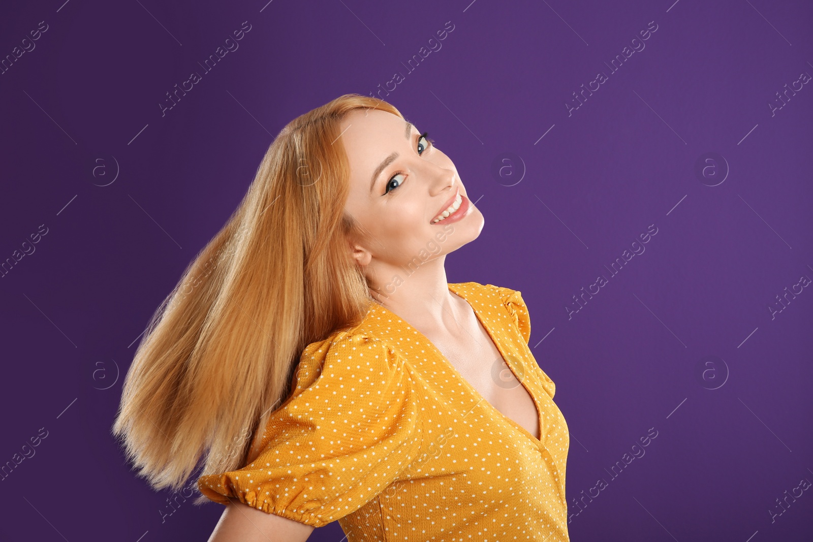 Photo of Beautiful young woman with blonde hair on purple background