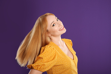 Photo of Beautiful young woman with blonde hair on purple background